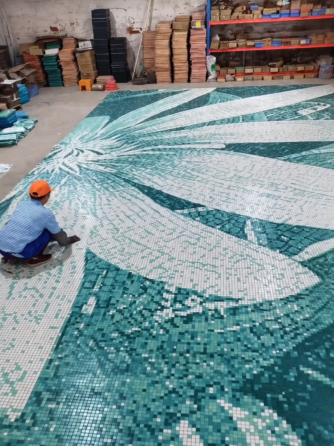 Large green and white mosaic artwork assembled in the workshop
